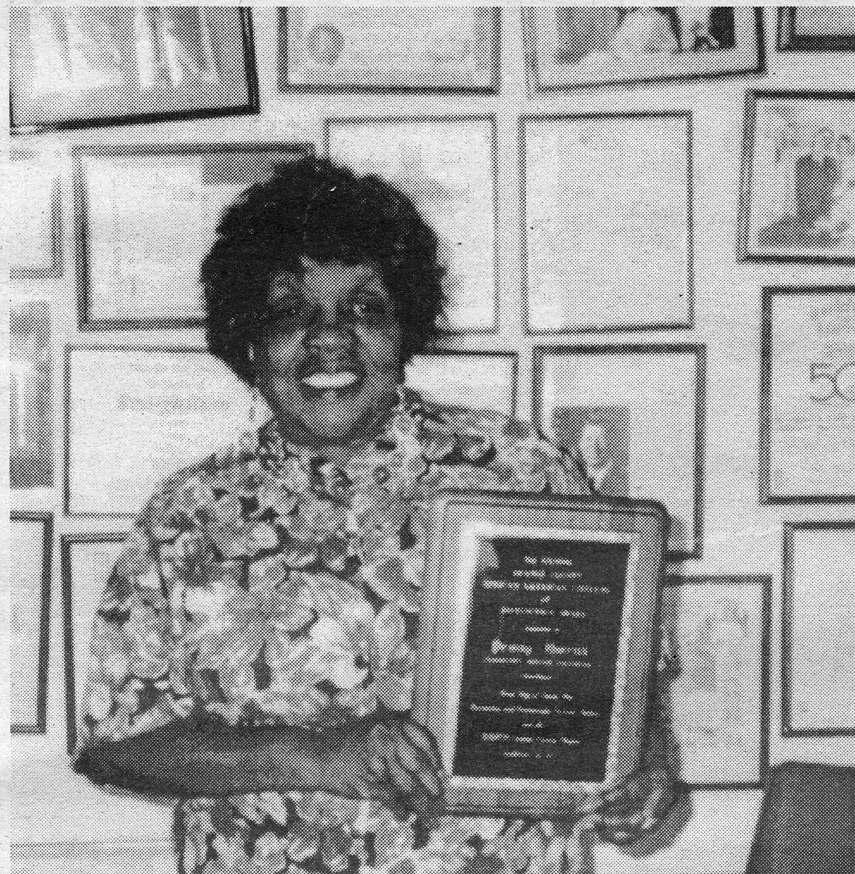 A photo of Penny Owens holding a plaque.